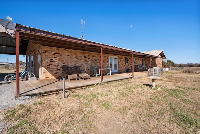 rear view of property with a wooden deck and french doors