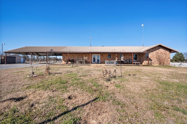 rear view of property featuring a yard and a shed