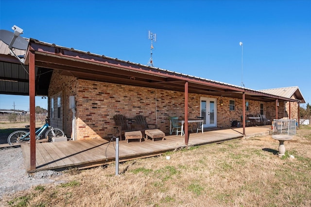 rear view of house with a wooden deck and french doors