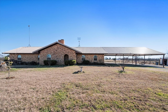 back of property with a lawn and a carport