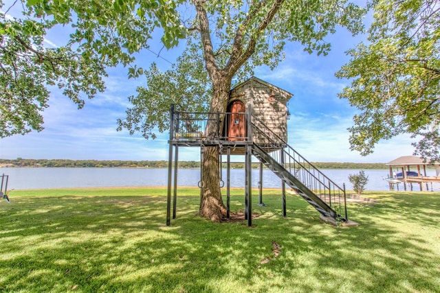 view of jungle gym with a water view and a lawn