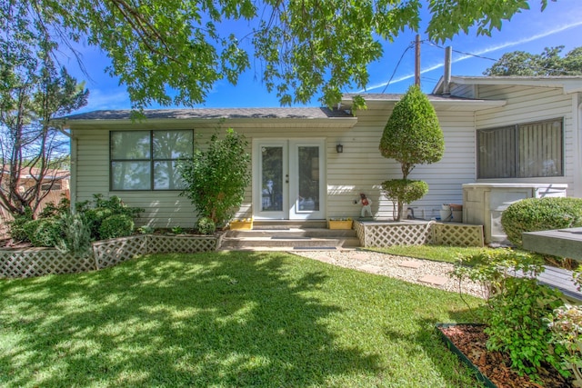 view of front of house with a front lawn and french doors