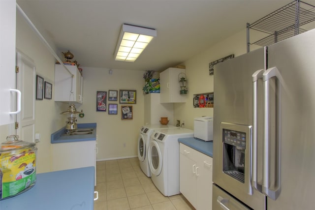 laundry room featuring cabinets, washing machine and dryer, and light tile patterned floors