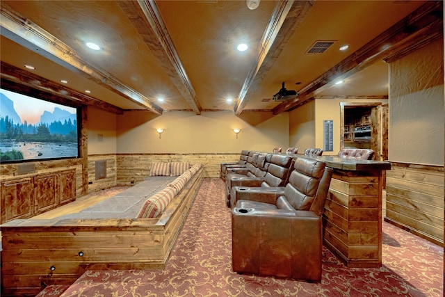 home theater room featuring beam ceiling and wooden walls