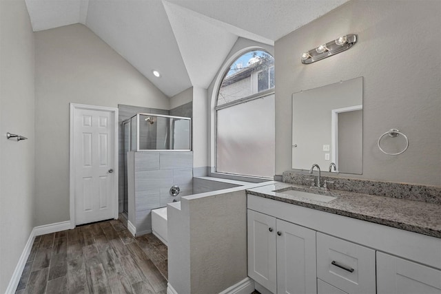 bathroom featuring hardwood / wood-style floors, vanity, a textured ceiling, vaulted ceiling, and shower with separate bathtub