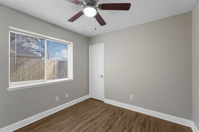 unfurnished room featuring ceiling fan, dark hardwood / wood-style floors, and a textured ceiling