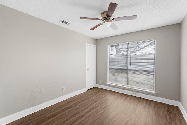 empty room with hardwood / wood-style floors, a textured ceiling, and ceiling fan