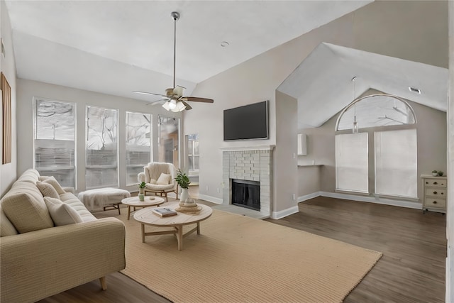 living room featuring ceiling fan, lofted ceiling, dark hardwood / wood-style flooring, and a brick fireplace