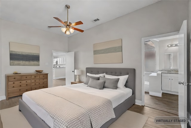 bedroom with ceiling fan, ensuite bathroom, sink, and hardwood / wood-style floors