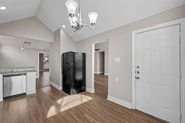 kitchen with black refrigerator, pendant lighting, dishwasher, lofted ceiling, and dark hardwood / wood-style flooring