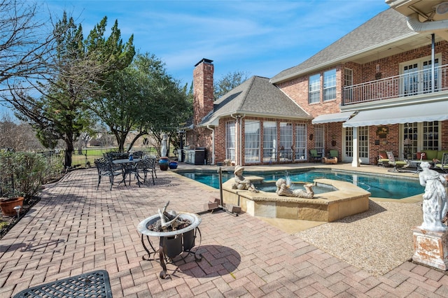 view of swimming pool with a patio area, an in ground hot tub, and a fire pit