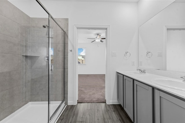 bathroom with hardwood / wood-style flooring, vanity, ceiling fan, and a shower with shower door