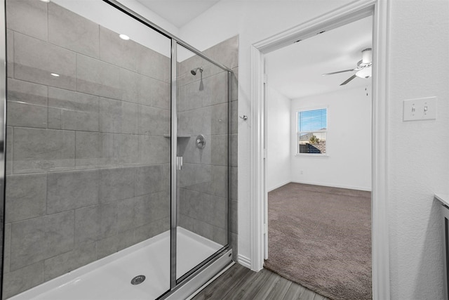 bathroom with walk in shower, ceiling fan, and hardwood / wood-style floors