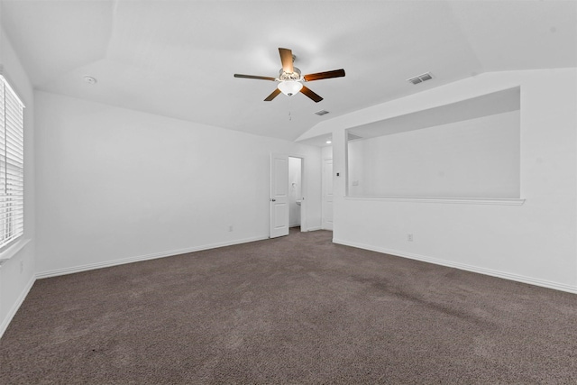 spare room featuring ceiling fan, lofted ceiling, and dark carpet