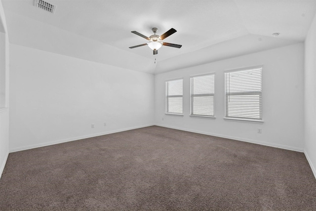 empty room with lofted ceiling, dark carpet, and ceiling fan