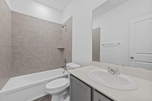 full bathroom featuring vanity, tiled shower / bath combo, toilet, and hardwood / wood-style flooring