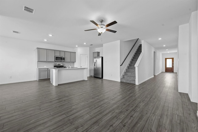 unfurnished living room featuring dark hardwood / wood-style flooring and ceiling fan