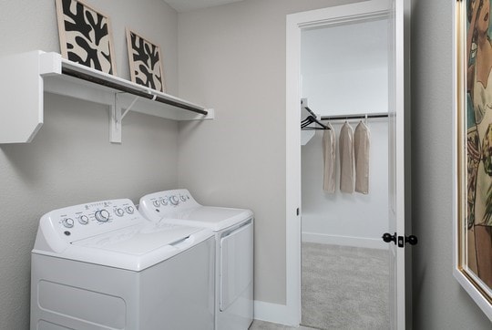 laundry area featuring light colored carpet and washer and dryer