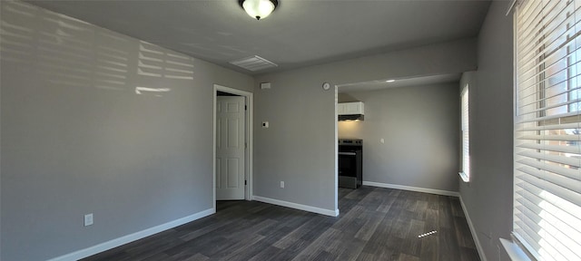 unfurnished room featuring dark wood-type flooring and plenty of natural light