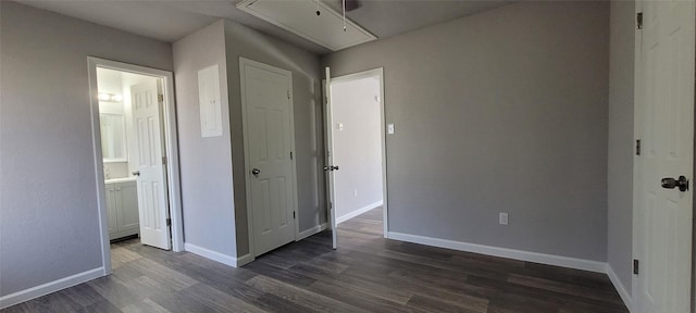 unfurnished bedroom featuring ensuite bath and dark hardwood / wood-style floors