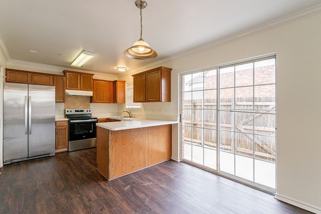 kitchen featuring under cabinet range hood, a peninsula, hanging light fixtures, appliances with stainless steel finishes, and light countertops