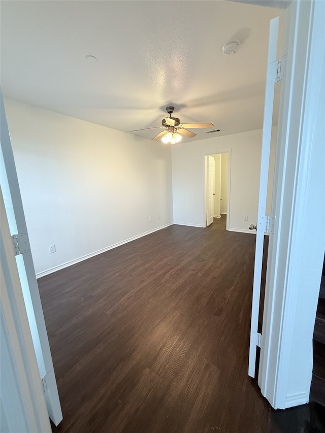 spare room featuring a textured ceiling, dark wood-type flooring, and ceiling fan