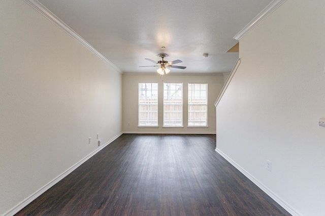 spare room with ceiling fan, baseboards, dark wood-type flooring, and crown molding