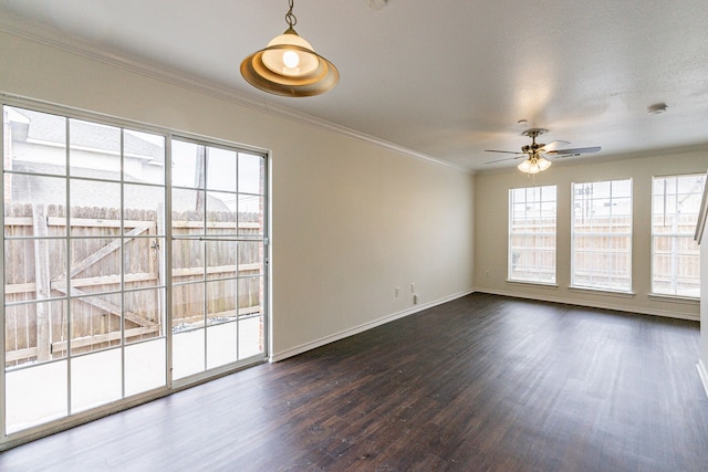 spare room featuring baseboards, dark wood finished floors, a ceiling fan, and crown molding