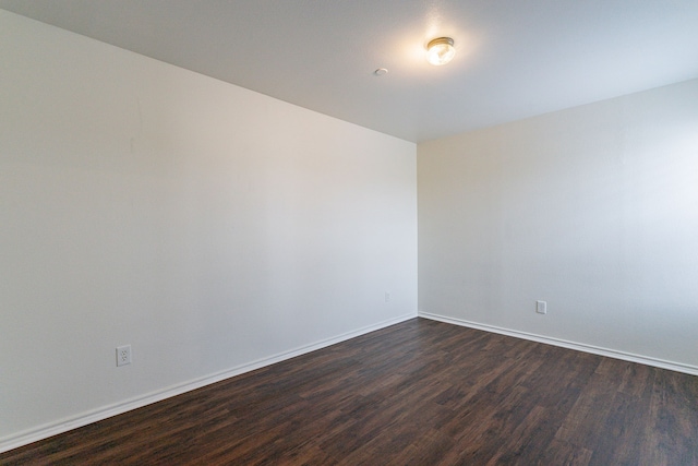 unfurnished room featuring dark wood finished floors and baseboards