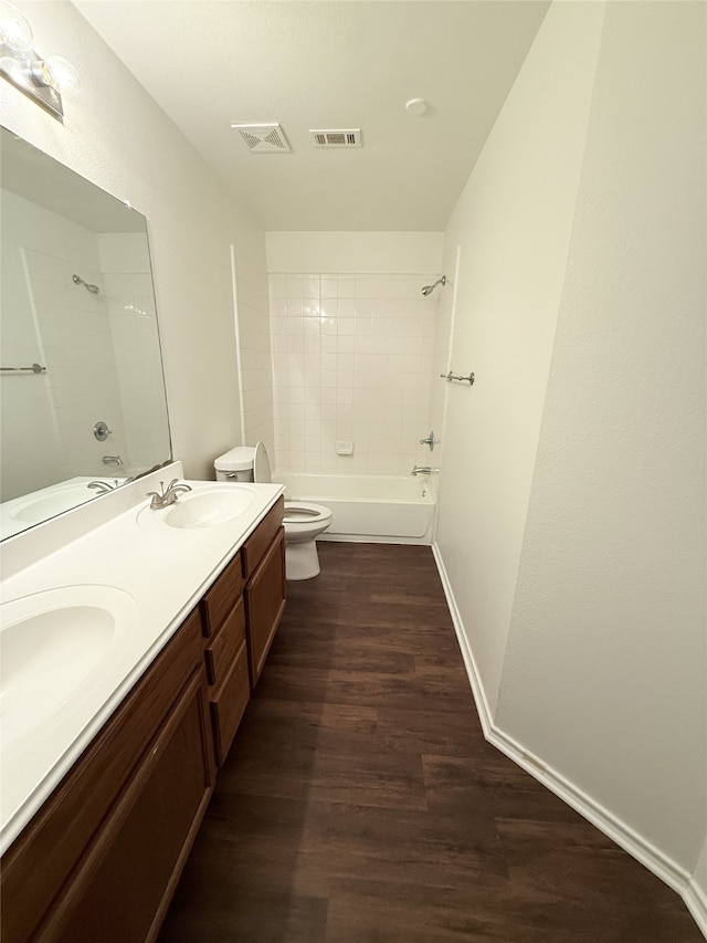 full bathroom featuring wood-type flooring, tiled shower / bath, vanity, and toilet