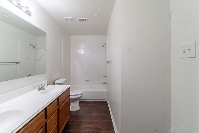 bathroom featuring toilet, visible vents, a sink, and wood finished floors