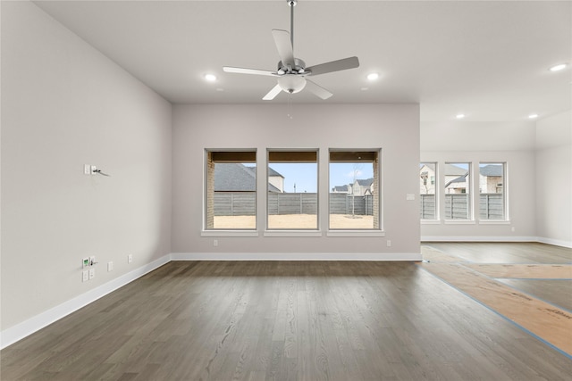 unfurnished living room with dark wood-style floors, baseboards, a ceiling fan, and recessed lighting