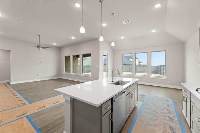 kitchen with open floor plan, stainless steel dishwasher, wood finished floors, and a sink