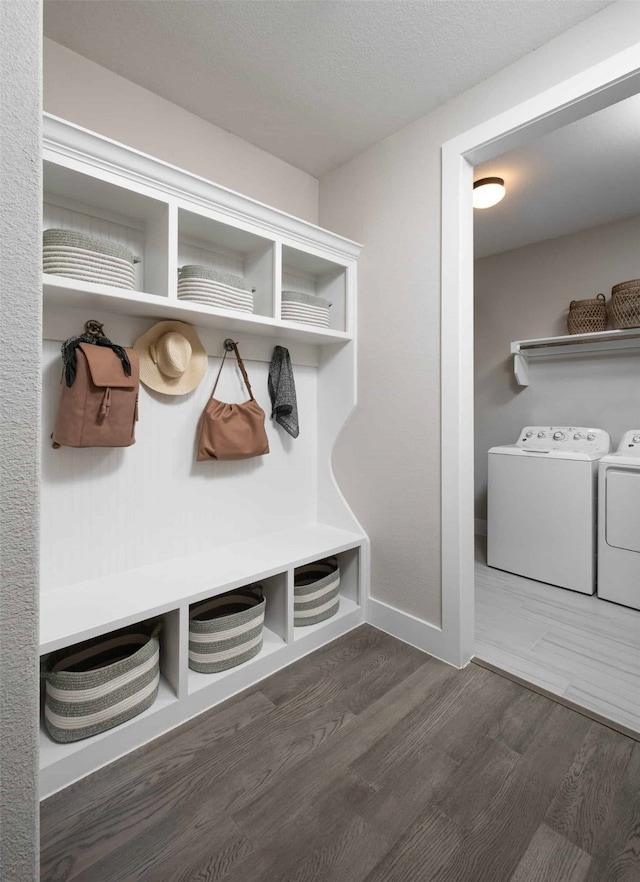 mudroom featuring washing machine and dryer, baseboards, and wood finished floors