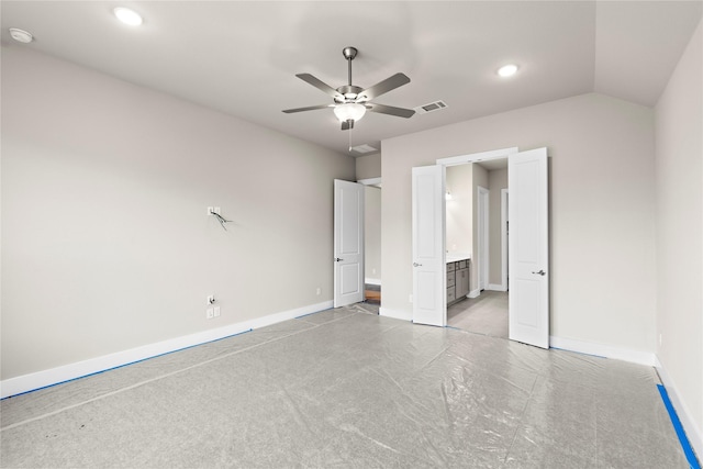 unfurnished bedroom with visible vents, a ceiling fan, vaulted ceiling, ensuite bath, and baseboards