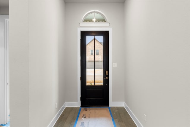 doorway featuring dark wood-style floors and baseboards