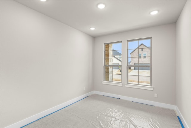 empty room featuring recessed lighting, concrete floors, and baseboards