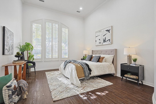 bedroom with crown molding and dark hardwood / wood-style flooring