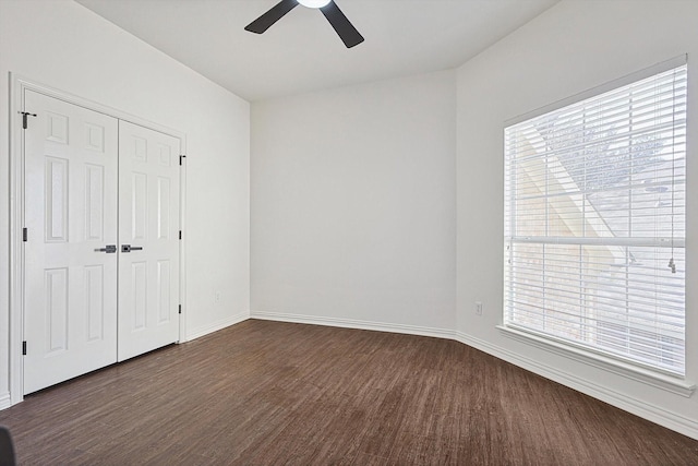 unfurnished bedroom with ceiling fan, dark hardwood / wood-style floors, and multiple windows