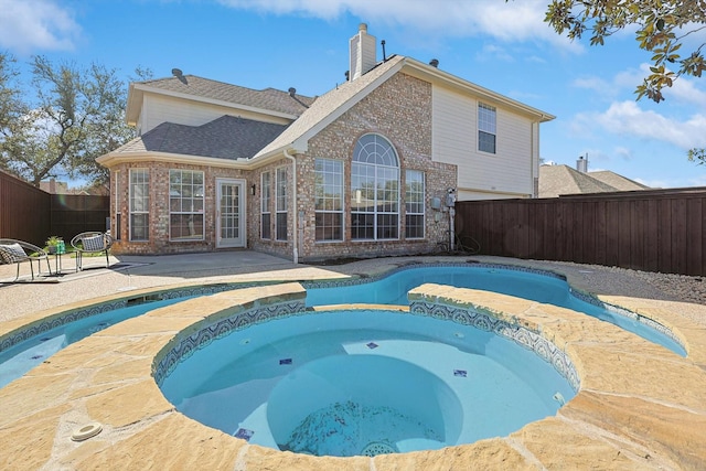 back of property with a pool with hot tub and a patio