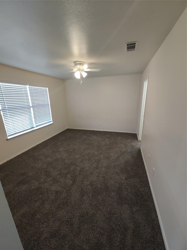 carpeted empty room with ceiling fan and a textured ceiling