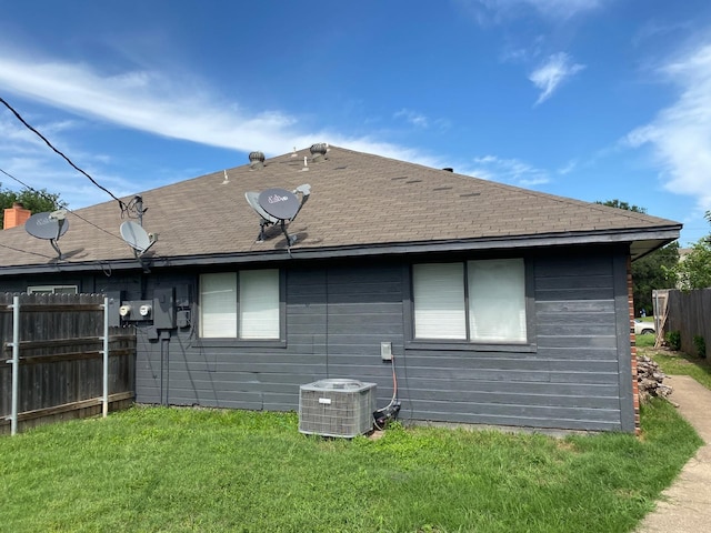 back of house with cooling unit and a yard