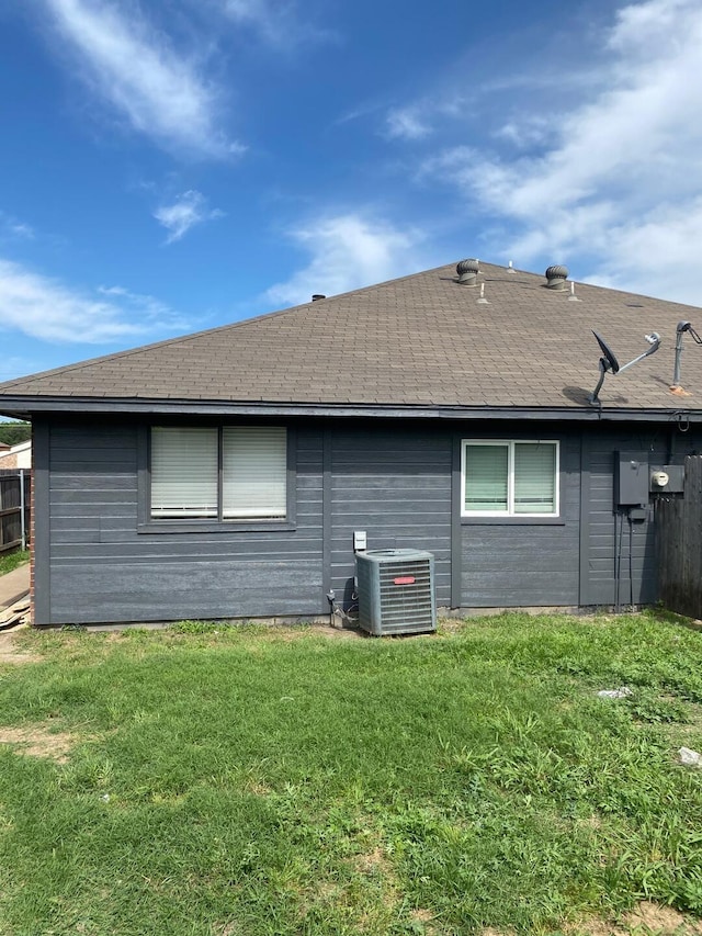 back of house featuring a yard and central AC