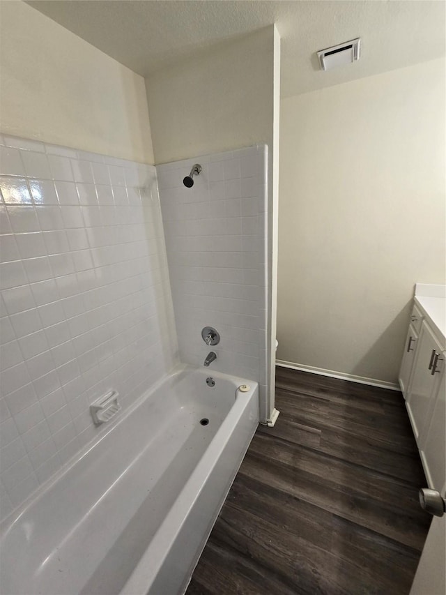 bathroom with vanity, hardwood / wood-style floors, a textured ceiling, and shower / bathing tub combination