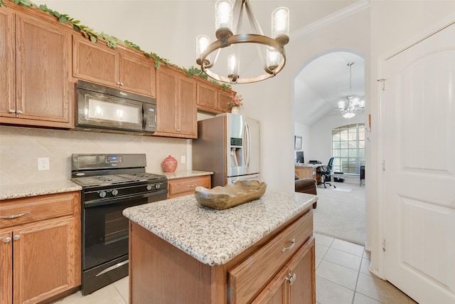 kitchen with a kitchen island, decorative light fixtures, tasteful backsplash, black appliances, and an inviting chandelier