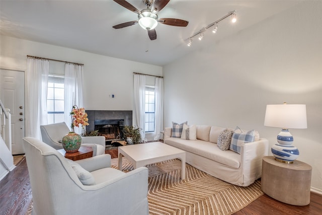 living room featuring dark hardwood / wood-style flooring, a fireplace, ceiling fan, and plenty of natural light