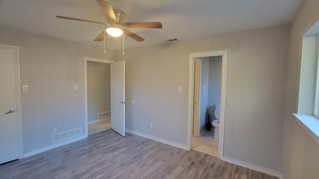 unfurnished bedroom with ceiling fan, ensuite bathroom, and light hardwood / wood-style floors