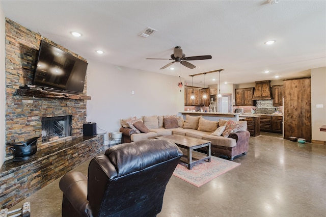 living area featuring visible vents, a ceiling fan, concrete flooring, a fireplace, and recessed lighting