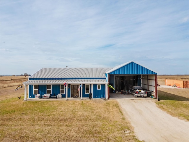 view of front of property with metal roof, covered porch, board and batten siding, and a front yard