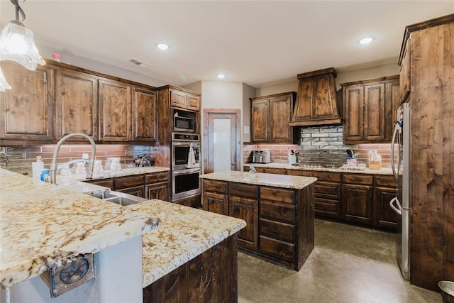 kitchen featuring light stone counters, a center island, hanging light fixtures, custom range hood, and stainless steel appliances